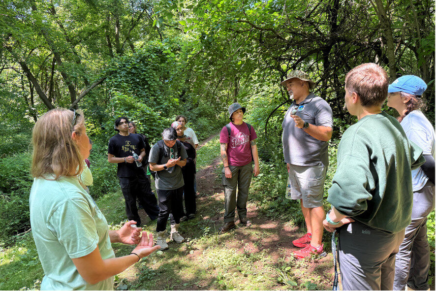 Christopher speaking to group of young adults while on a hike through his property