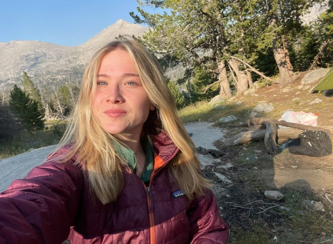 person taking a selfie while at a campsite in the mountains