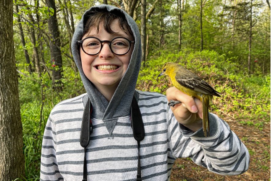 child holding orchard oriole during bird banding field trip by paul stillmank