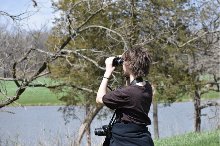 person looking through binoculars while birding