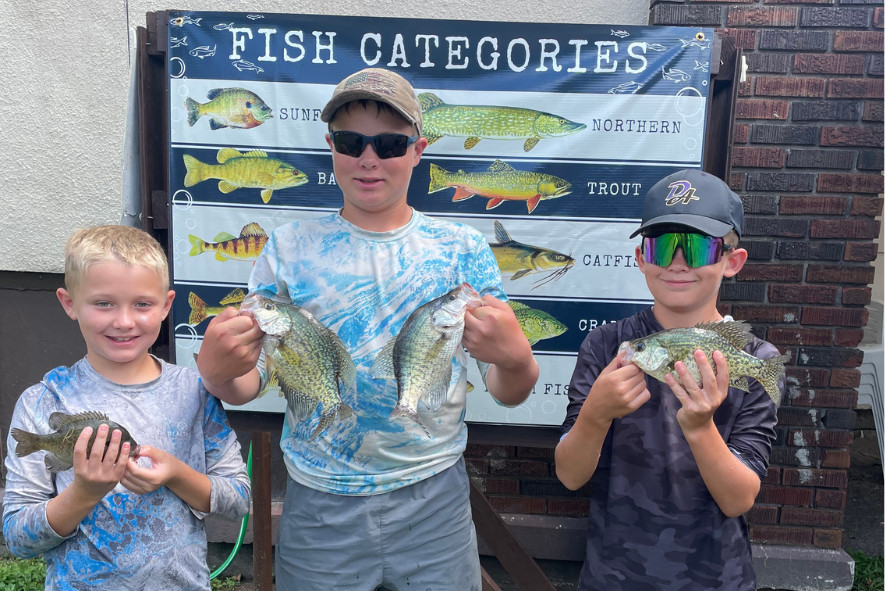 kids holding up small fish at a fishing contest