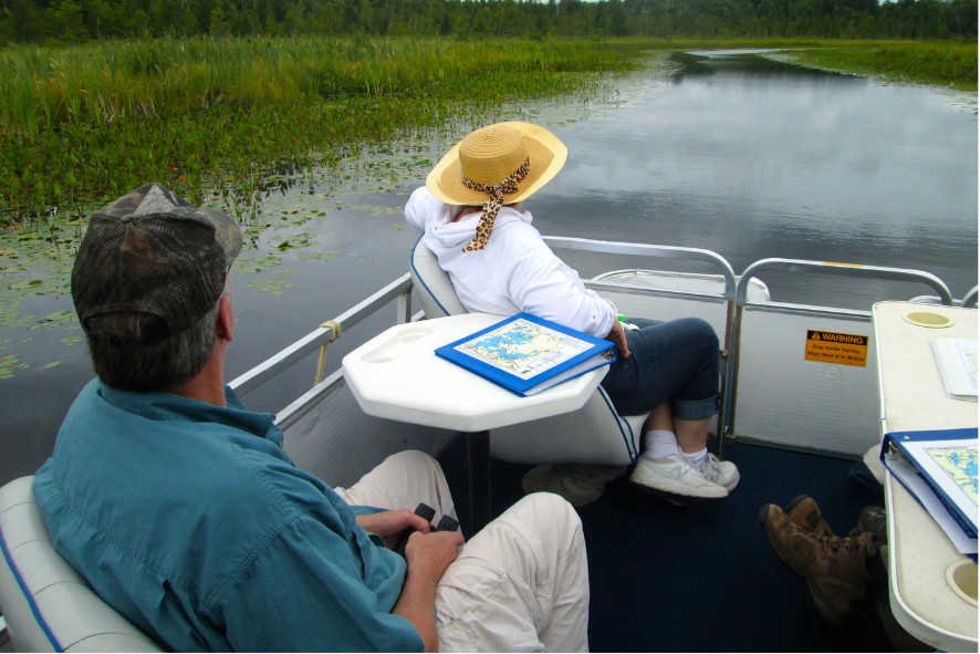 people sitting on a pontoon boat