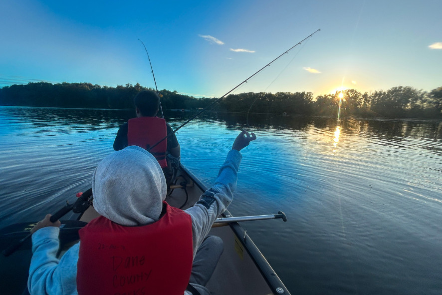 people fishing on a boat at sunset